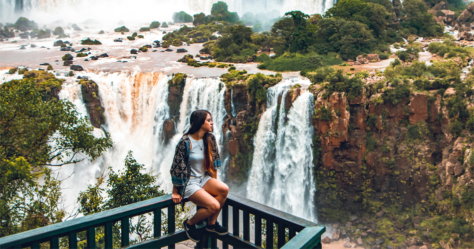 Iguazu Falls tours - Iguazu Falls with a girl sitting looking at the horizon