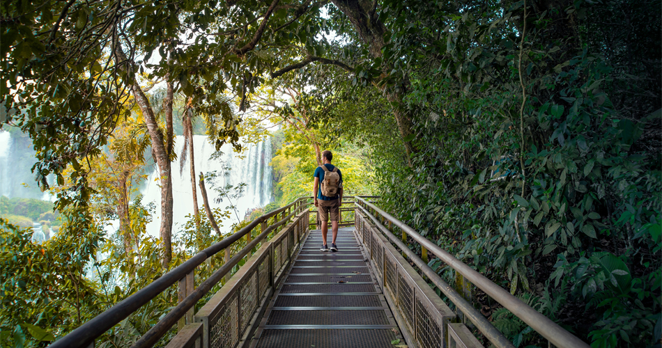 Iguazu Falls tours - man traveler with a backpack explores Iguazu Falls