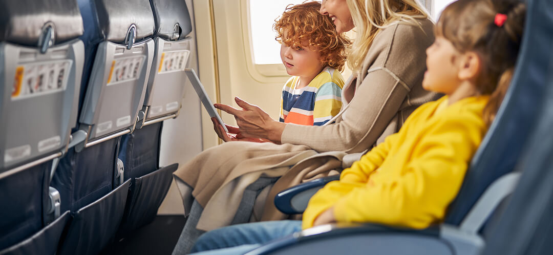 family sitting in economy class airplane seats