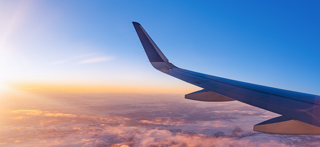 long haul flight wing view at sunrise