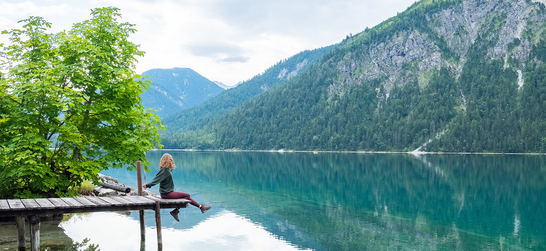 solo female traveler by mountain lake