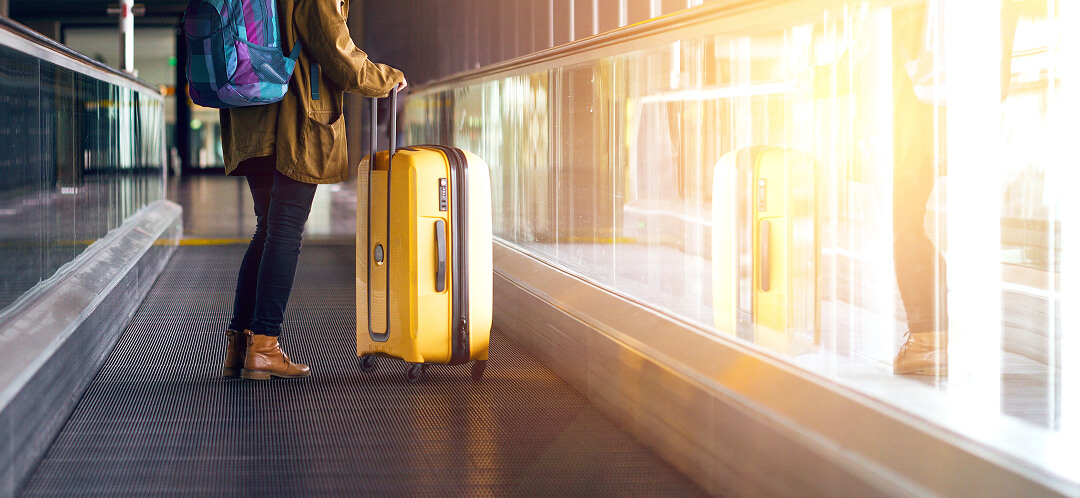 airport traveler with yellow suitcase