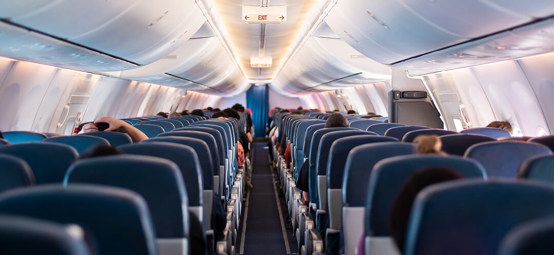 passengers seated in airplane economy cabin